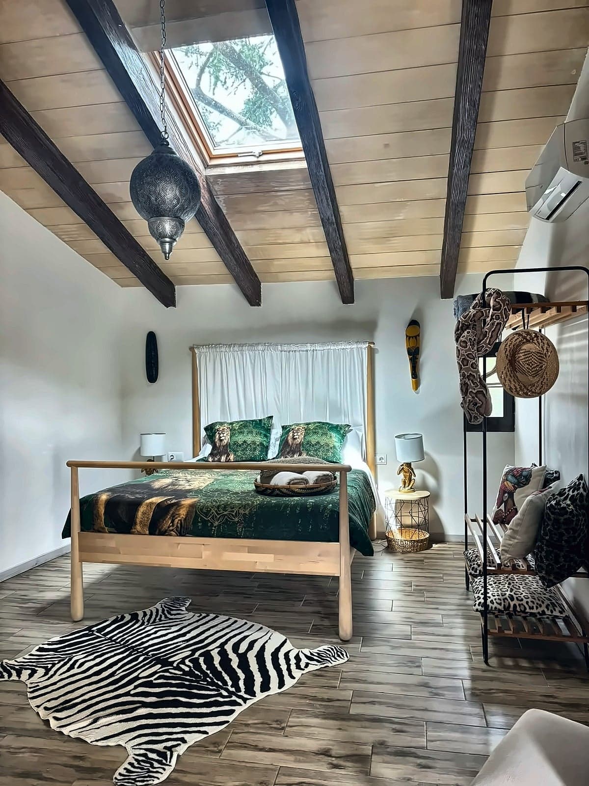 Llit amb dosser de cortines blanques, roba de llit estampada de lleons i claraboia, Habitació Africana